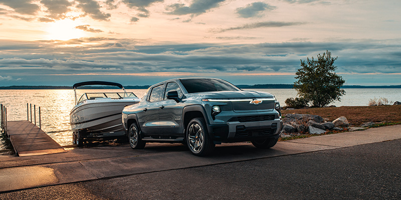 2026 Silverado EV in Laurel parked at sunset, showcasing its sleek design.